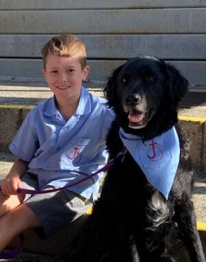 Boy and dog in matching blue shirts.