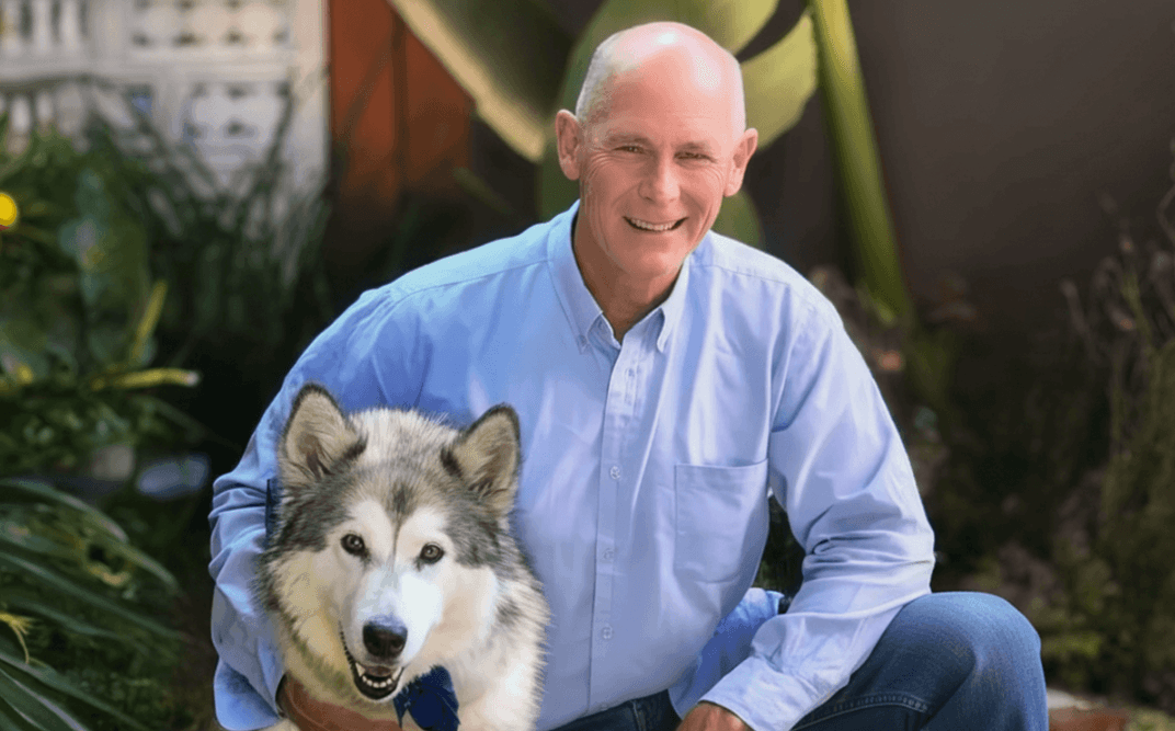 Smiling man with dog in garden