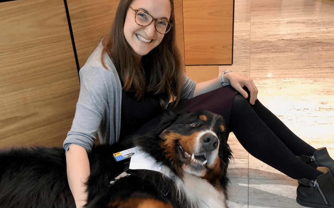 Woman sitting with happy dog indoors
